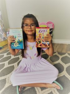 Girl holding up two books
