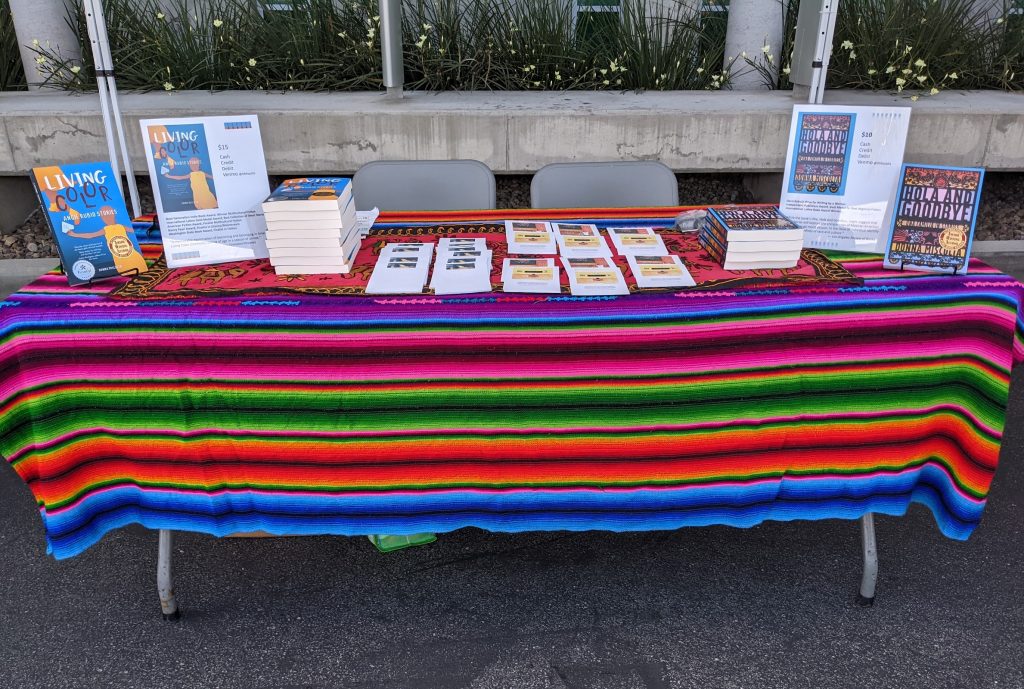 Table covered with a Mexican blanket upon which are displayed books for sale