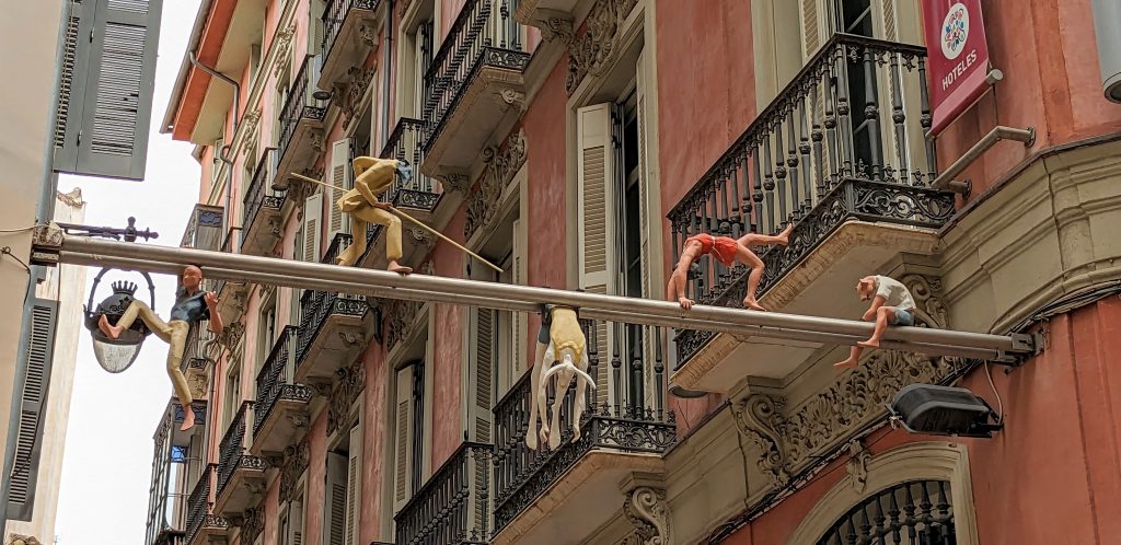 Acrobat figurines suspended across two buildings