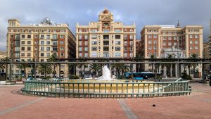 Main avenue in Malaga Span with fountain in front of three buildings