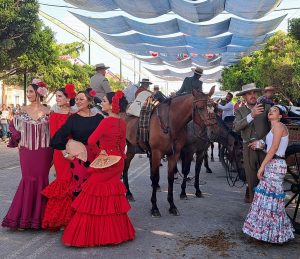 Women in Flamenco dresses with horses in background