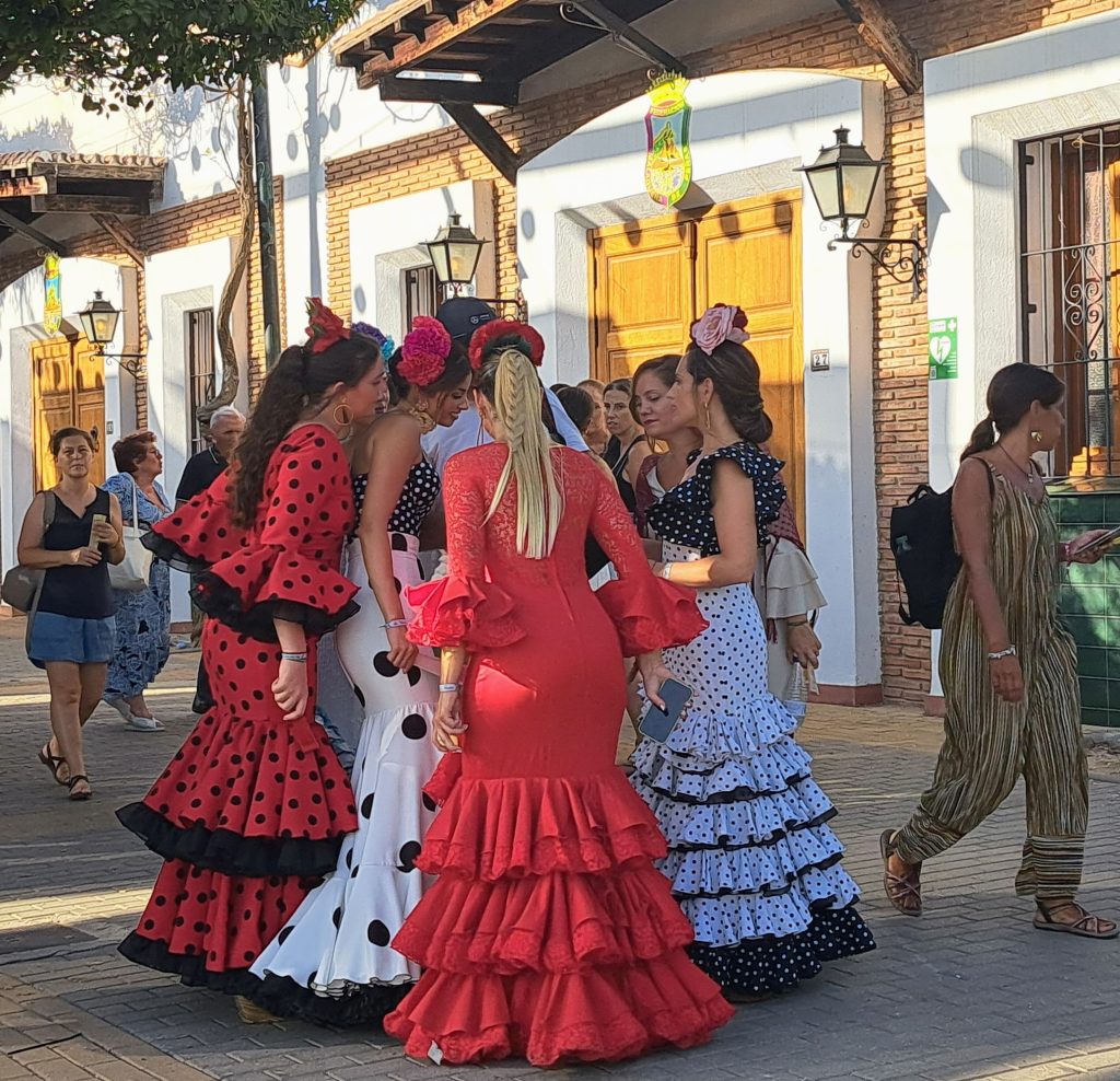 A group of young women in Flamenco wear gather in a circle