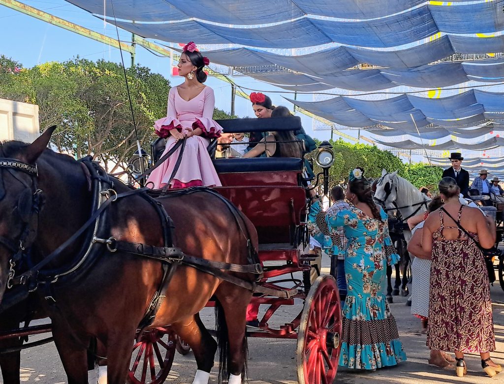 Woman in Flamenco dress atop a horse-drawn carriage