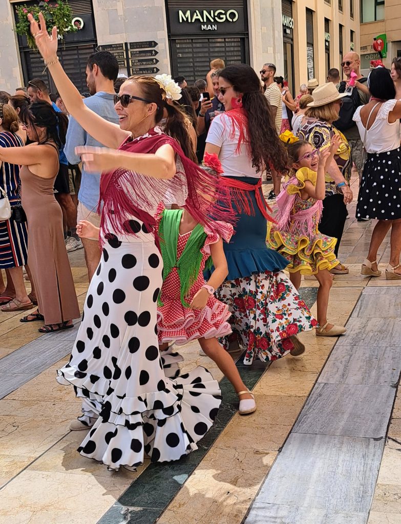 Two women and two small girls in Flamenco wear dance in a Malaga street