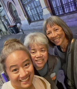 Close-up selfie of three brown women in a Madrid street