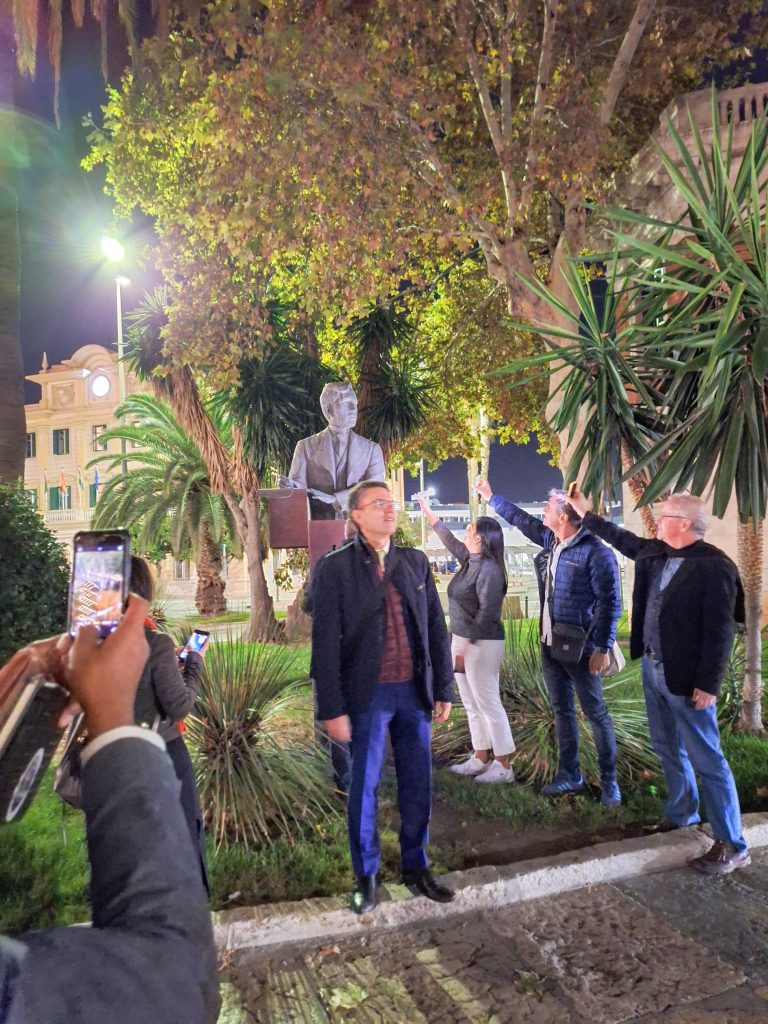 Three people illuminating the statue of Jose Rizal in Malaga with their cell phones
