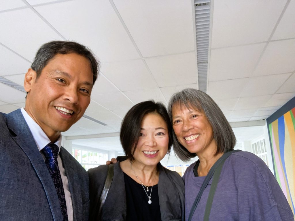 A Filipino American man in his fifties with two Filipina American women of similar age