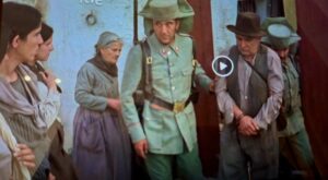 Movie clip showing two Guardia Civil escorting a prisoner through a door.