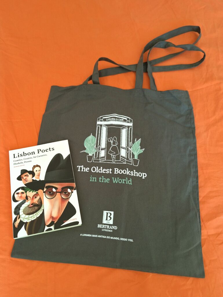 Book bag imprinted with Livraria Bertrand bookstore logo with a book of poetry by Lisbon poets next to it