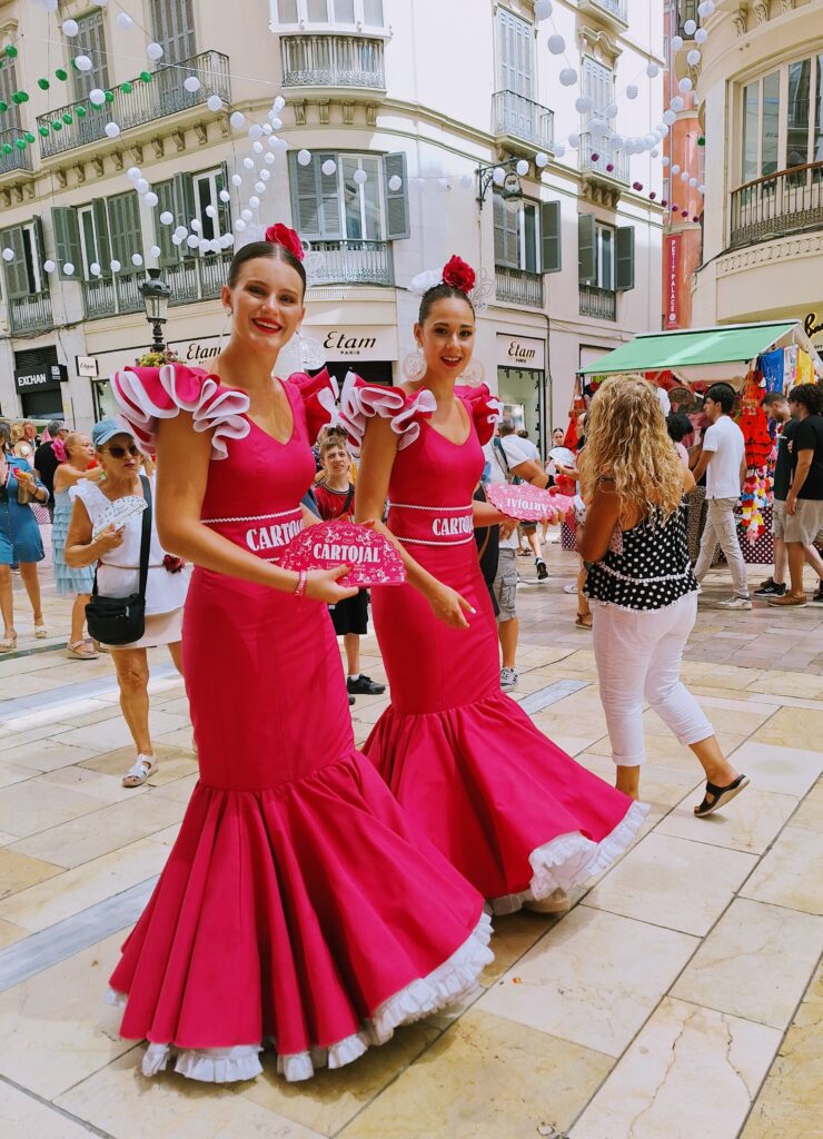 Two tall, young women dressed alike in pink Flamenco dresses