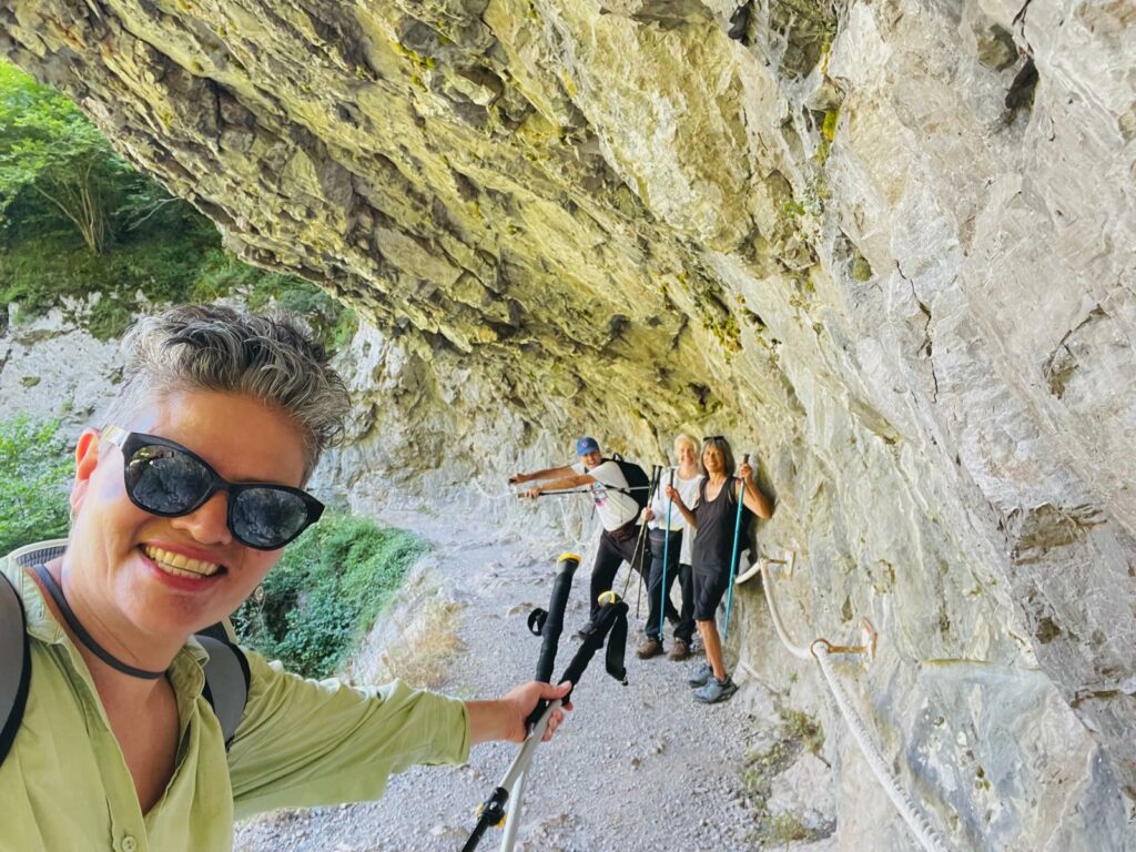 Hikers posing under a rocky ledge in Asturias, Spain