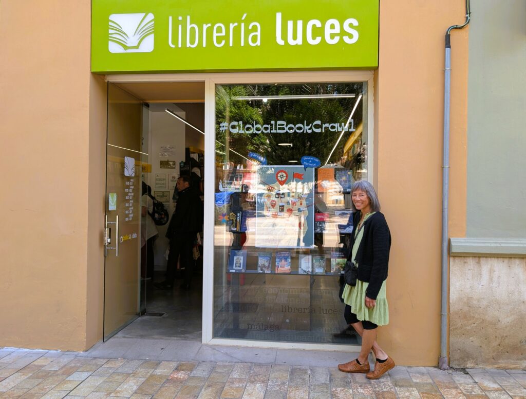 Woman standing at entrance to Libreria Luces, a bookstore in Malaga, Spain.