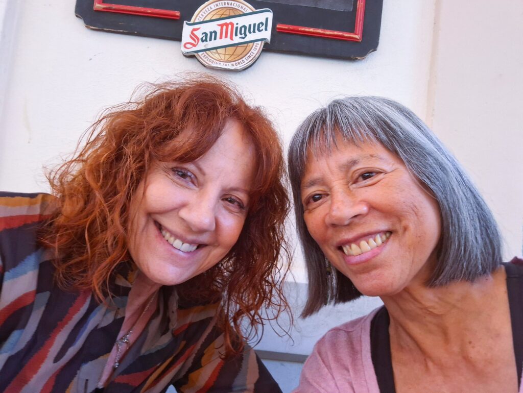 Headshot of two middle-aged women, one redhead and one graying.