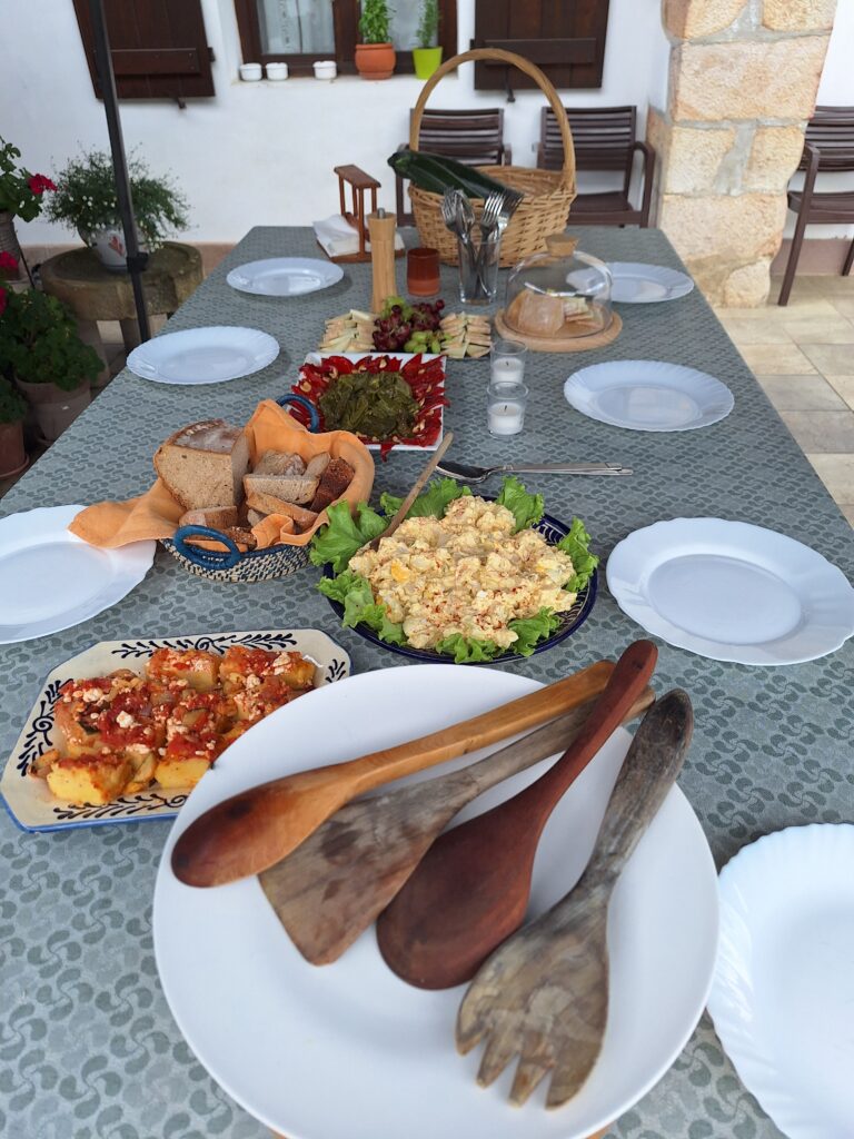 A table on a terrace set for lunch with various foods