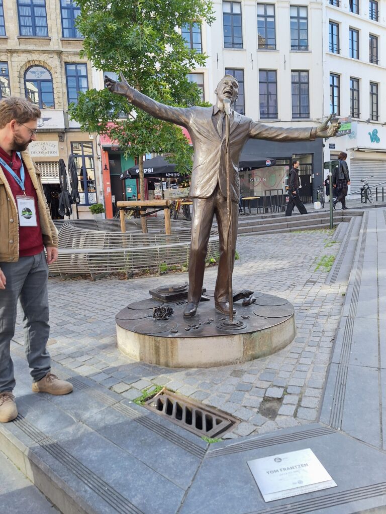 Statue of Jacques Brel with tour guide looking on in Brussels