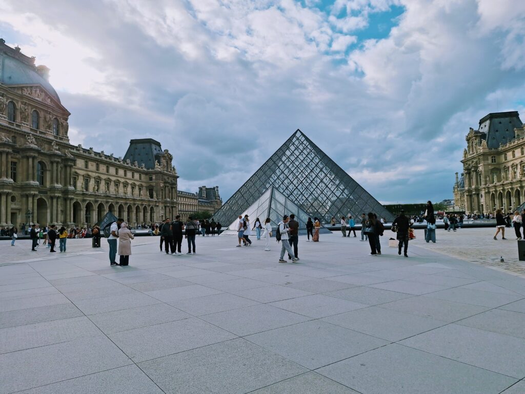 The Louvre Pyramid with tourists in front