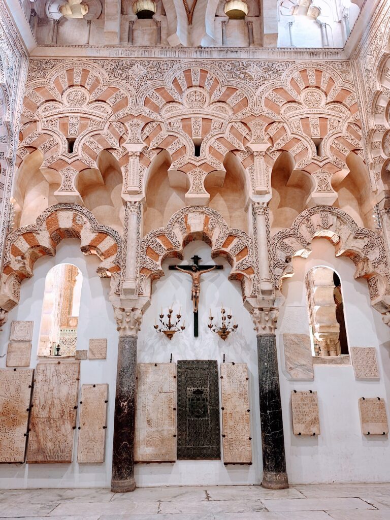 View of a crucifix hung among the Islamic arches inside the Great Mosque of Cordoba, Spain.