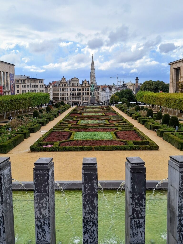 Geometric garden in Brussells. Lomg rectangle of hedges and flowers flanked on either side by shrubs