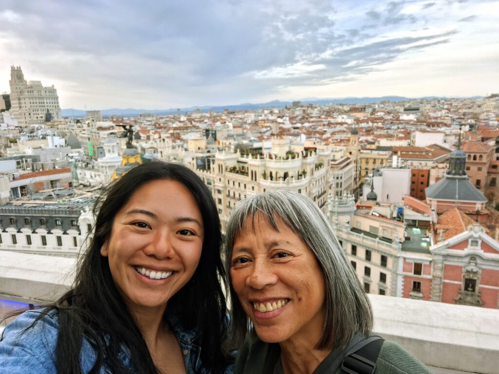 Two Asian American women on a rooftop bar in Madrid on a cloudy day