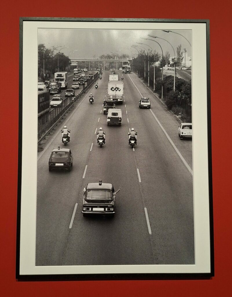 A truck being escorted down the highway by police escorts on motorcycles and patrol cars.