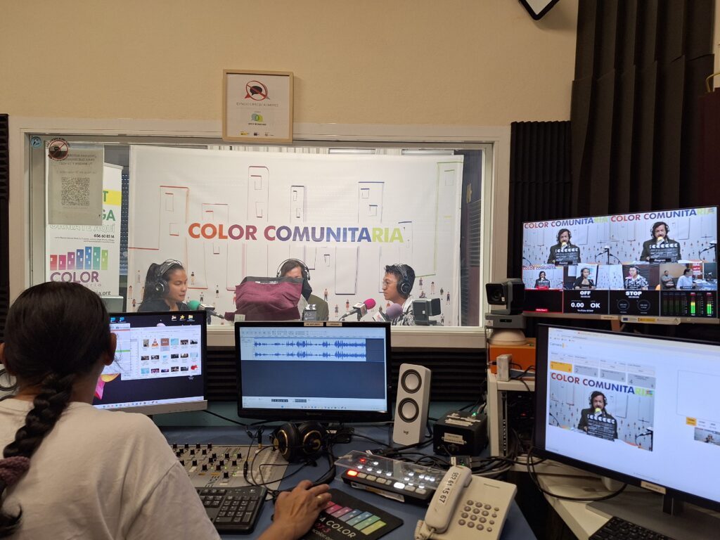 Three people are recording a show in a studio. Outside the studio the technician monitors the recording on various screens.